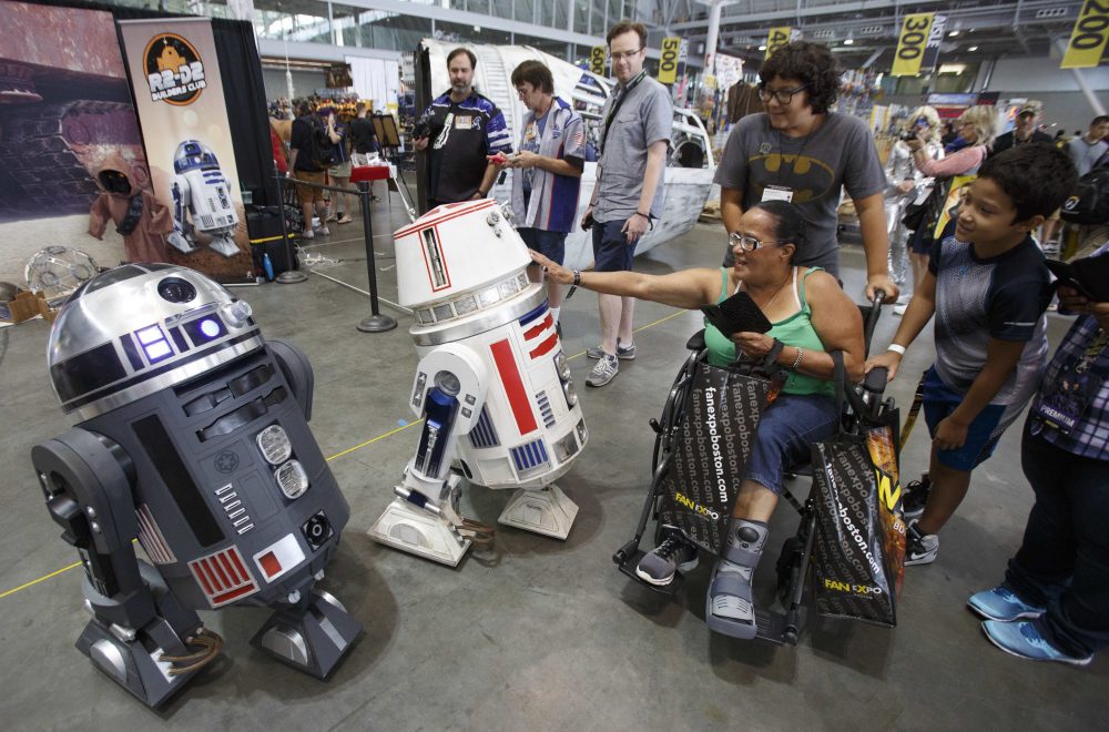 A woman checks out the remote controlled R2-D2s. (Michael Dwyer/AP)