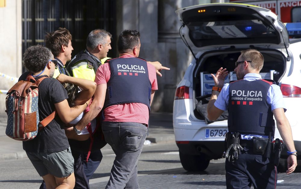 An injured person is carried in Barcelona, Spain, Thursday after a van jumped the sidewalk in the historic Las Ramblas district, crashing into a summer crowd of residents and tourists and leaving 13 dead and dozens injured. (Oriol Duran/AP)