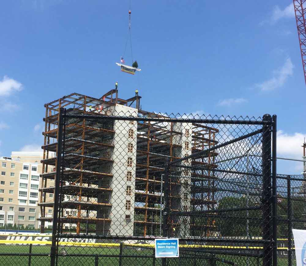 The final steel beam is placed on the first dorm at UMass Boston on Aug. 3. (Fred Thys/WBUR)