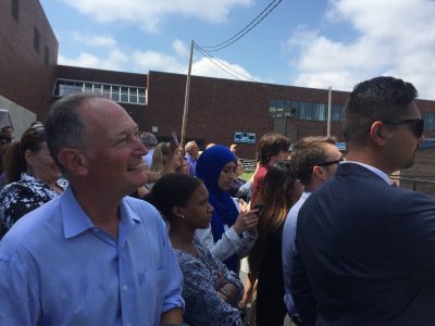 Barry Mills, interim chancellor of UMass Boston, watches the final steel beam placed on the campus's first dorm on August 3rd. (Fred Thys/WBUR)