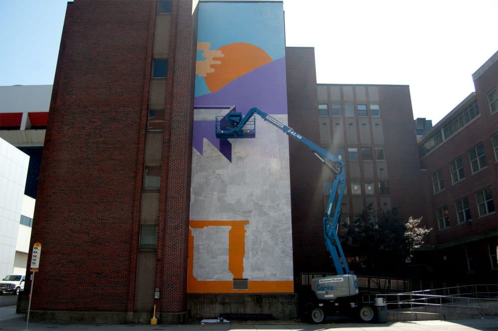 Tim McCool works on his sunrise mural during the last week of September at 774 Albany St., Boston. (Greg Cook/WBUR)
