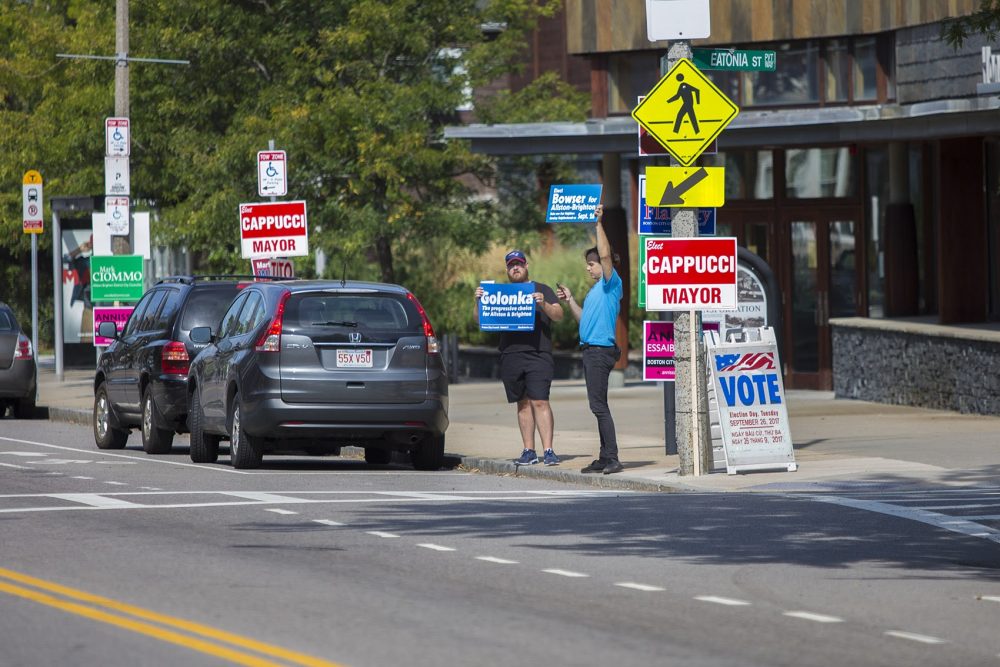 Cody Ward and David Whelpley campaigned outside in front of the Honan-Allston Library. (Jesse Costa/WBUR)