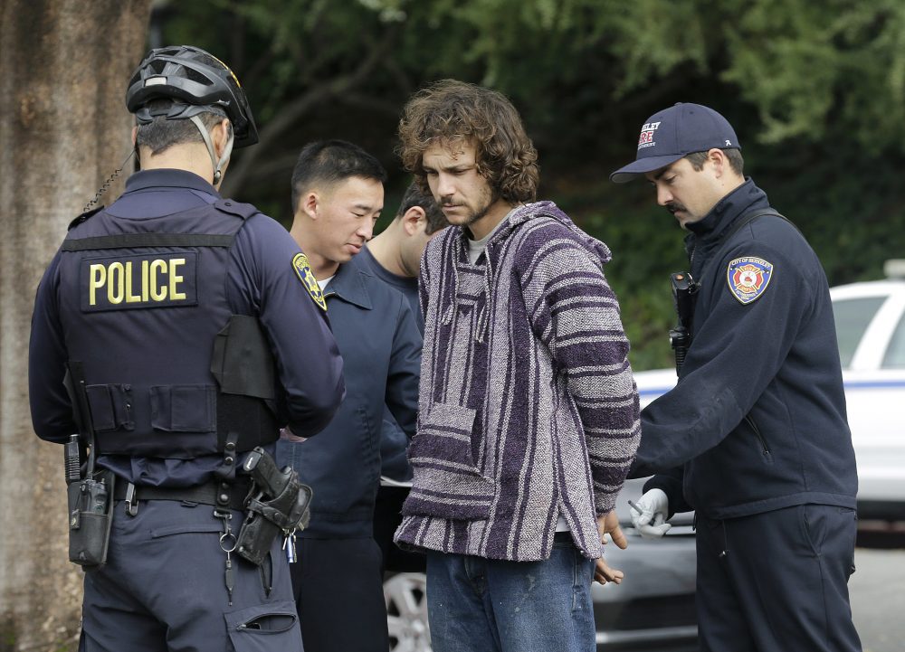 Police officers arrest a man who attacked a student on the University of California, Berkeley campus Thursday, Feb. 2, 2017. Jack Palkovic, a student wearing a "Make America Great Again" hat, was attacked on the Berkeley campus a day after violent protests led authorities to cancel a controversial speech. (Jeff Chiu/AP)