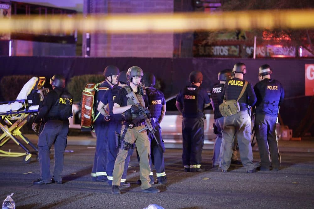 Police officers and medical personnel stand near the Mandalay Bay Resort and Casino on the Las Vegas Strip early Monday morning. More than 50 people died, and more than 500 were injured, in the deadliest mass shooting in modern U.S. history. (John Locher/AP)
