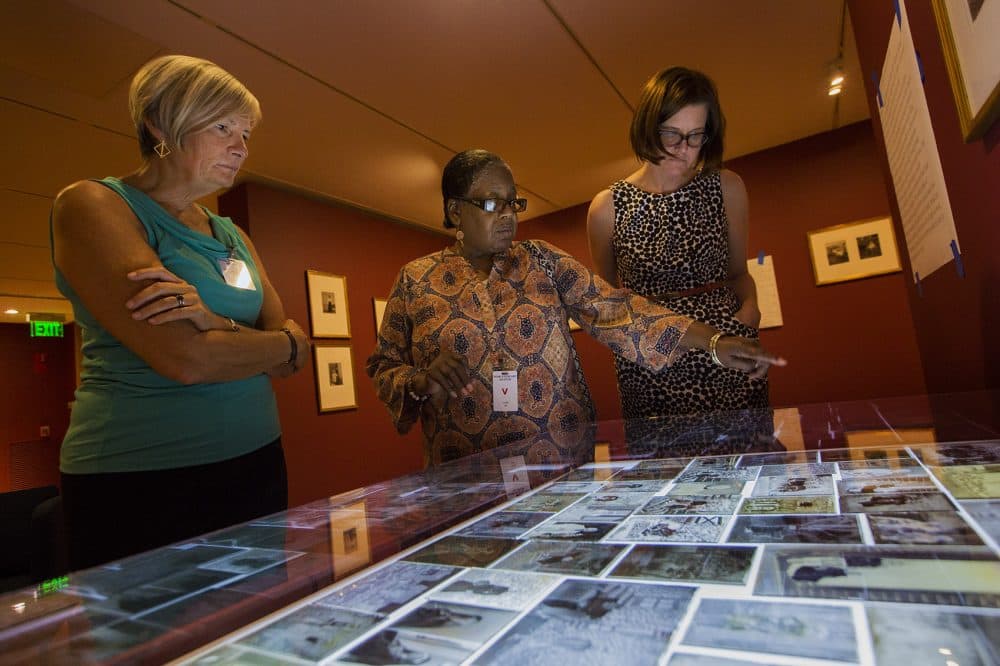 Professor Janette Greenwood, Benetta Kuffour and curator Nancy Burns look at the negatives. (Jesse Costa/WBUR)