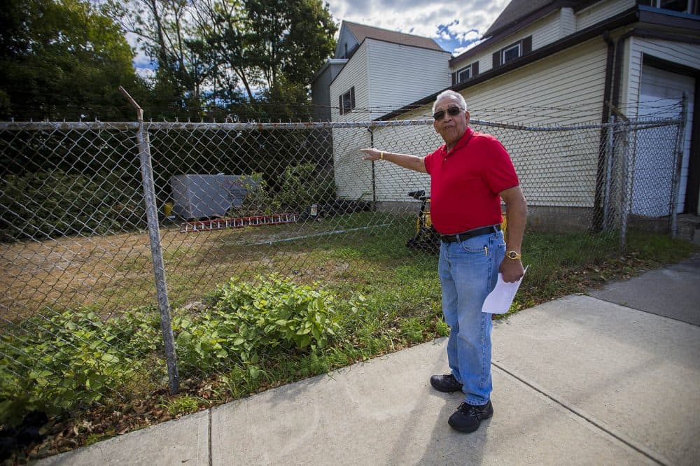Nick Schuyler points at the vacant lot where his home used to be. (Jesse Costa/WBUR)