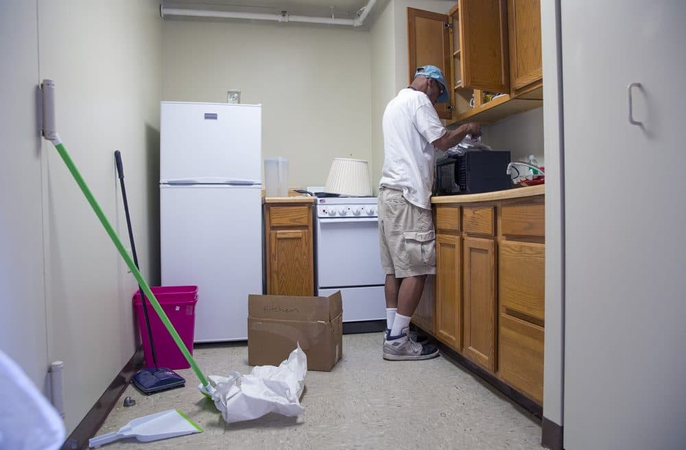 Higginbottom unpacks in his new apartment. (Robin Lubbock/WBUR)