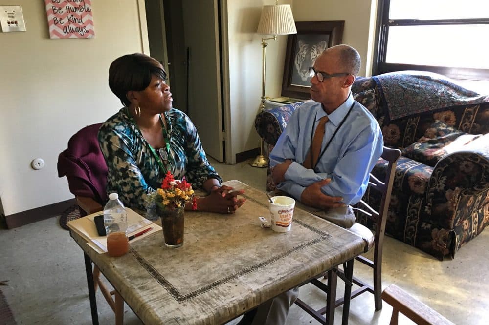 Watson, from Pine Street Inn, visits with Higginbottom in his furnished apartment. (Lynn Jolicoeur/WBUR)