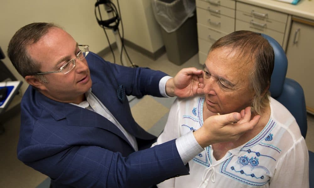 Surgeon Dr. Jeffrey Spiegel demonstrates to Goodhue where along her jaw line the feminine facial surgery would occur. (Jesse Costa/WBUR)