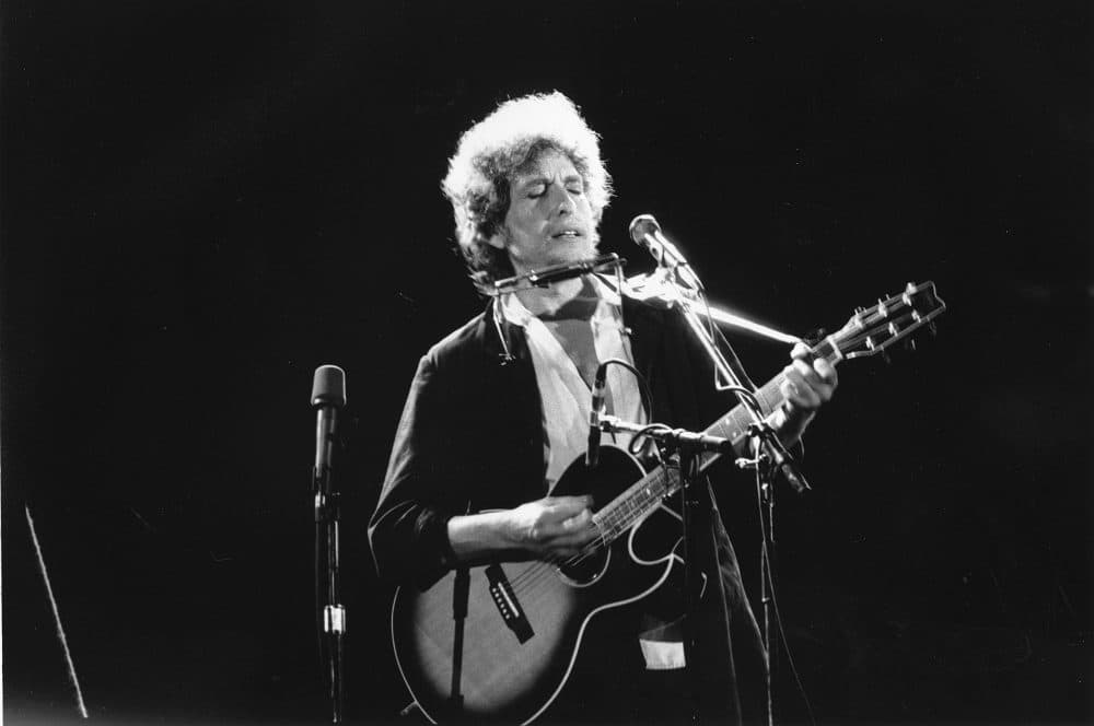 An undated photo of singer-songwriter Bob Dylan as he plays his acoustic guitar with his harmonica at an unknown location. (AP)