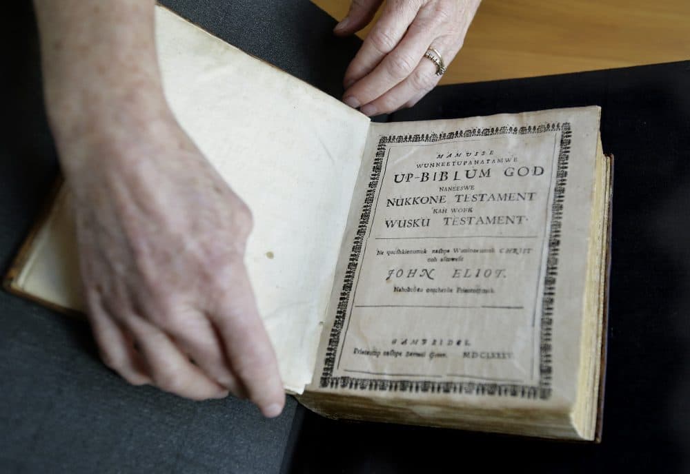 Massachusetts Institute of Technology archivist Nora Murphy places a second edition of the Eliot Indian Bible on a table at the MIT rare book collection, in Cambridge. The second edition of the Eliot Indian Bible, translated into Wampanoag, is dated 1685. Experts have relied on extensive written records in Wampanoag to reclaim the language, including 17th century phonetic translations of the King James Bible. (Steven Senne/AP)
