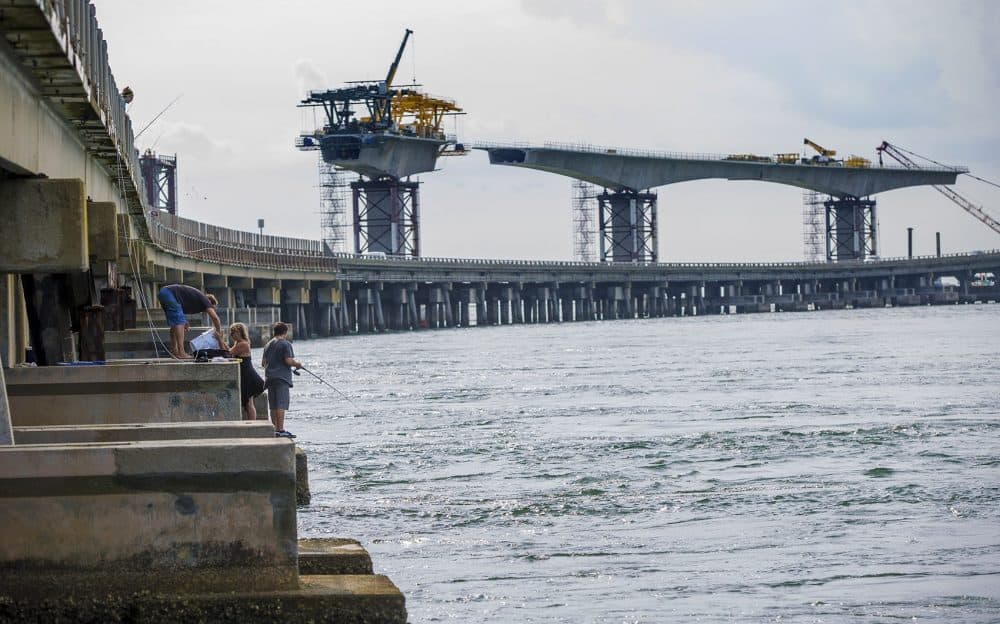 Young people fish off of the Herbert Bonner Bridge which is soon to be replaced by a new 2.8 mile long bridge that is designed to have a 100-year life span. (Jesse Costa/WBUR)