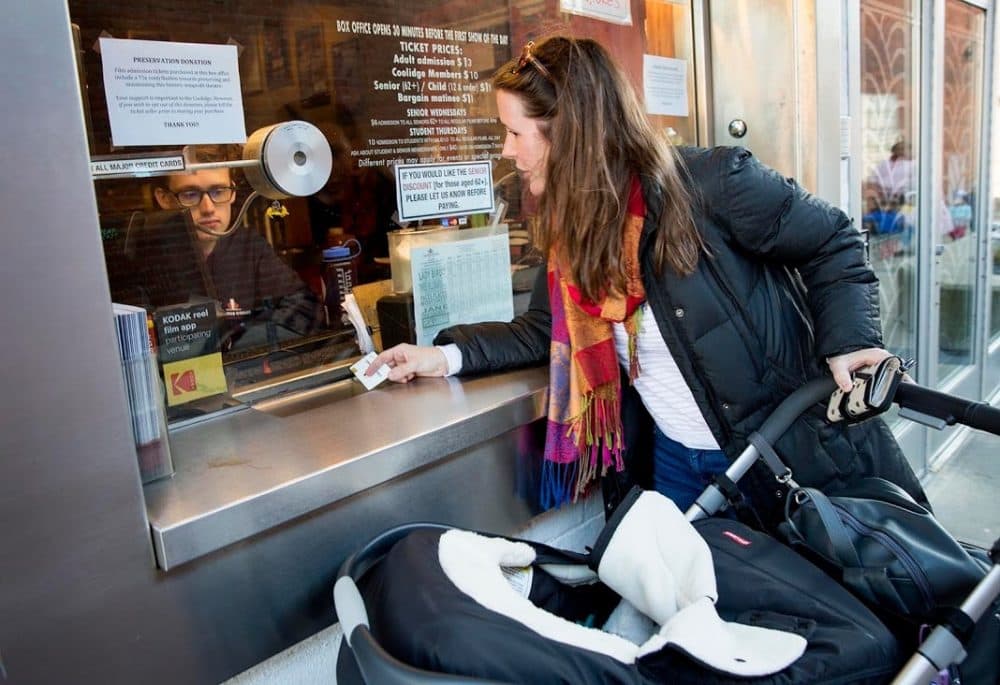 Monica McEnrue buys a ticket for the Box Office Babies screening of "Face Places" at the Coolidge Corner Theatre. Her 11-week-old daughter Maisie Lee waits quietly in her stroller. She'll get in free. (Robin Lubbock/WBUR)