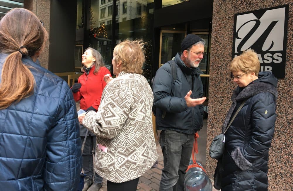 Tom Goodkind and others gather at a protest outside Boston's UMass Club. (Max Larkin/WBUR)