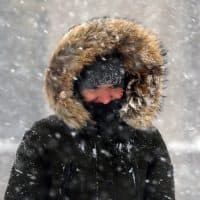 A woman walks in blowing snow in downtown Boston, Thursday, Jan. 4, 2018. A massive winter storm swept from the Carolinas to Maine on Thursday, dumping snow along the coast and bringing strong winds that will usher in possible record-breaking cold. (Michael Dwyer/AP)