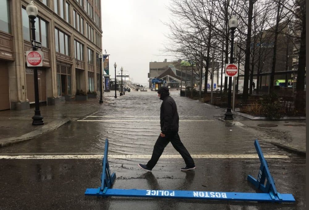 Water floods streets in front of the New England Aquarium. (Robin Lubbock/WBUR)