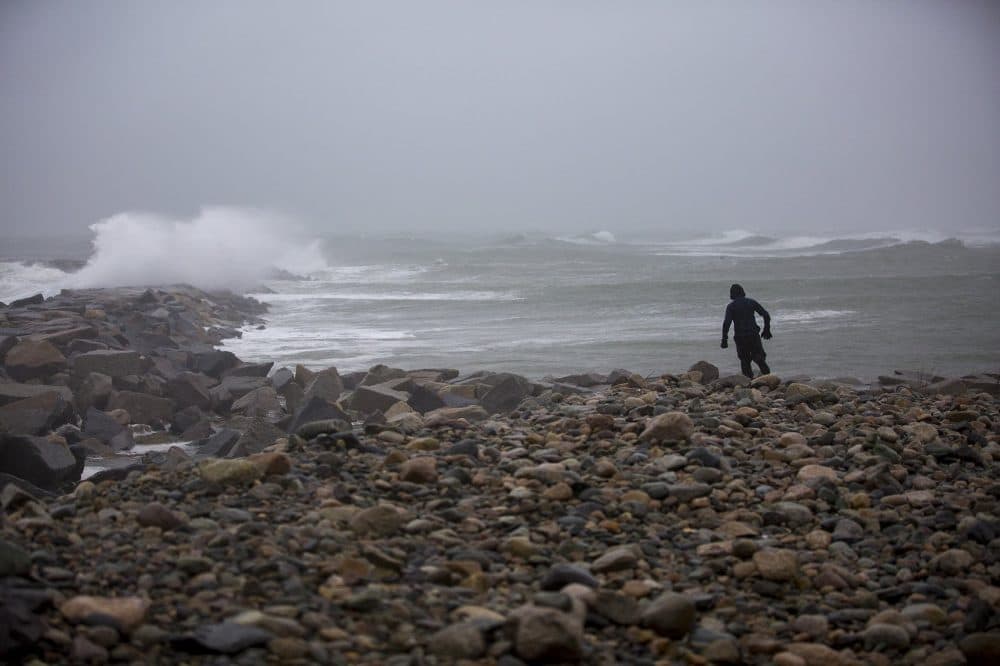 Brennan Kane, 12, braves the rain and high winds to walk out toward the sea wall at the Scituate Lighthouse. (Jesse Costa/WBUR)