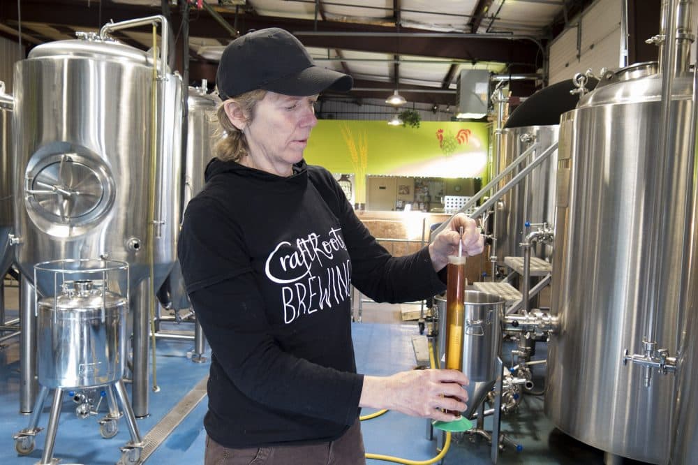 CraftRoots Brewer and Founder Maureen Fabry tests the specific gravity of one of the beers she is brewing. (Andrea Shea/WBUR)