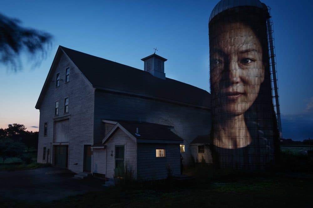 A portrait of Jennifer Hyoje-Ryu Kenty projected onto a barn's silo at Alexander Farm in Winchendon. (Courtesy Erik Jacobs)