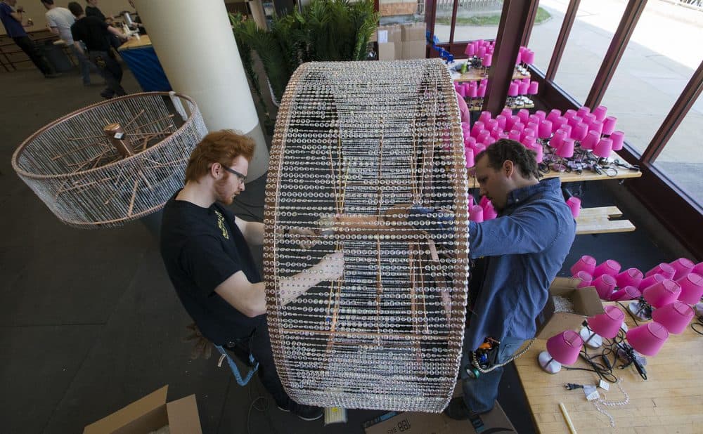Joseph Gurkan, left, and Taylor Hansen work on a chandelier. (Jesse Costa/WBUR)