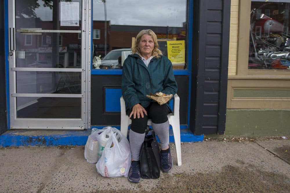 Debra Kimberly Findlay sits in a chair in front of the Mission Restaurant in downtown Smiths Falls. Findlay says she has no interest in a marijuana job, and that the arrival of Canopy is only reinforcing the town's image as a down-on-its luck kind of place. "They'll just call it the 'Dope Town,' " she says. (Jesse Costa/WBUR)