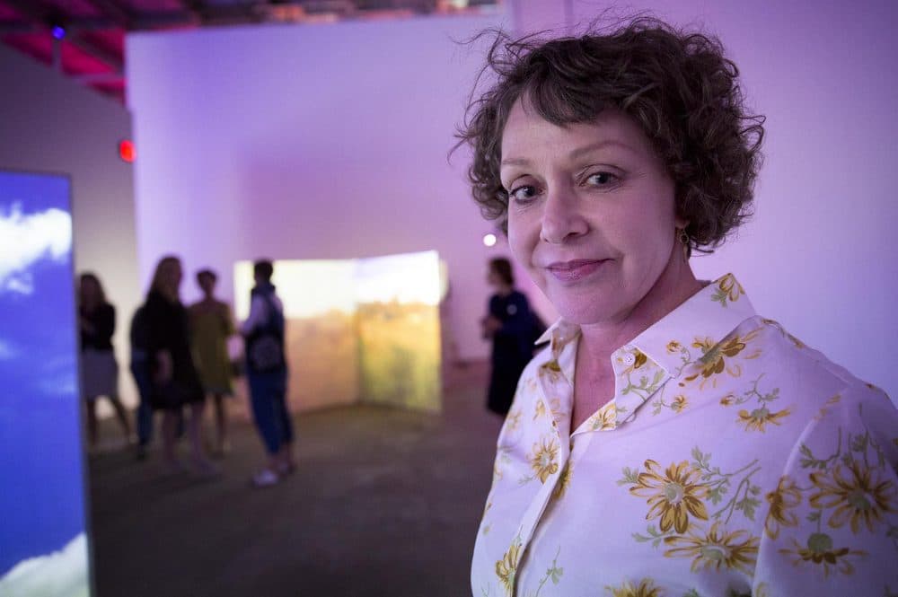 Artist Diana Thater, surrounded by her work, at the inaugural exhibition of the ICA Watershed in East Boston. (Robin Lubbock/WBUR)