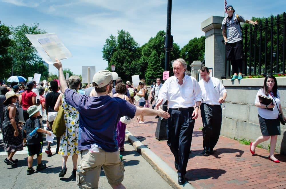 Sen. Ed Markey shakes hands with protestors marching past the State House at the "Keep Families Togather" rally. (Elizabeth Gillis/WBUR)