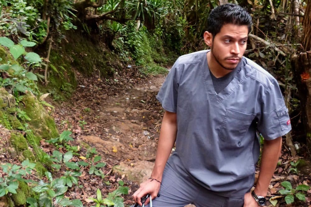 Dr. Marco Corea hikes to the home of Ludis and Gledia Rodriguez. Corea diagnosed Gledia with autism and anxiety. (Karyn Miller-Medzon/Here & Now)