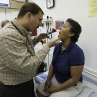 Dr. Javier Hiriart, left, examines a patient during a medical checkup at Camillus Health Concern in Miami on Sept. 8, 2009.(Lynne Sladky/AP)