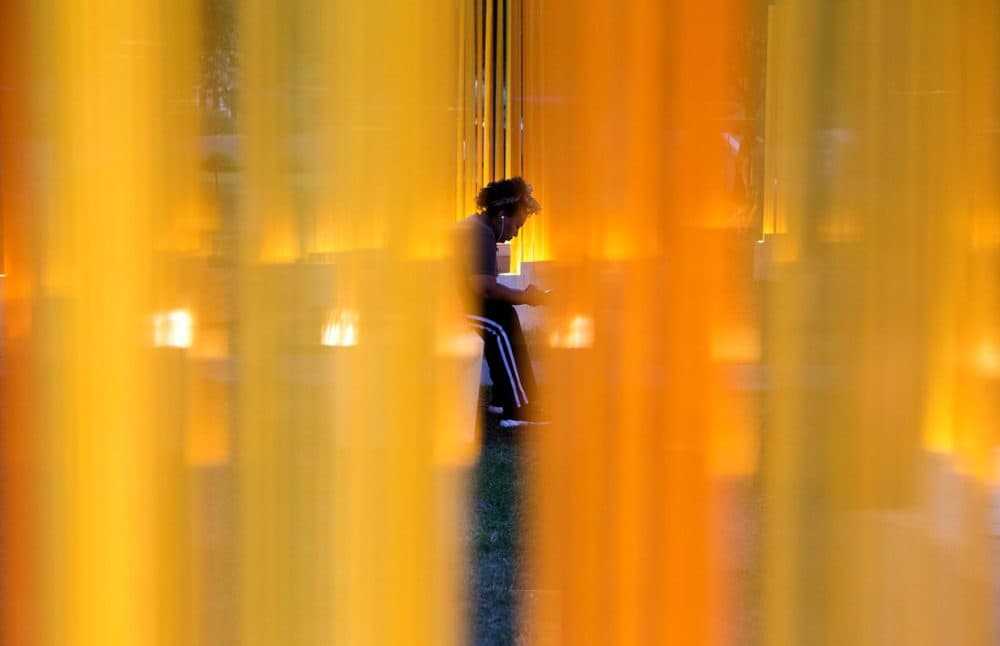A visitor sits in one of the inner circles of Teresita Fernández's "Autumn (…Nothing Personal)." (Robin Lubbock/WBUR)