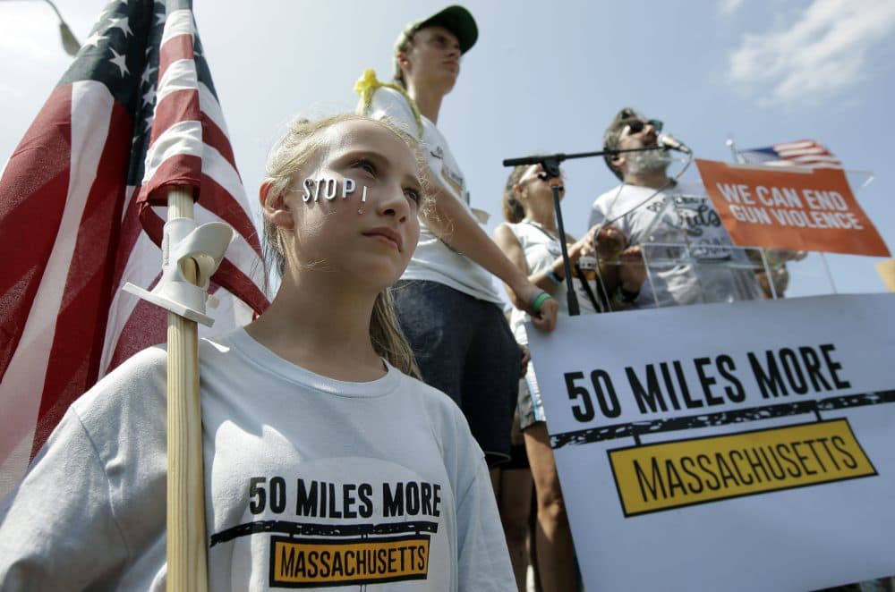 Jessica Sullivan, of Dover, left, holds an American flag during a rally near the headquarters of Smith & Wesson Sunday. (Steven Senne/AP)