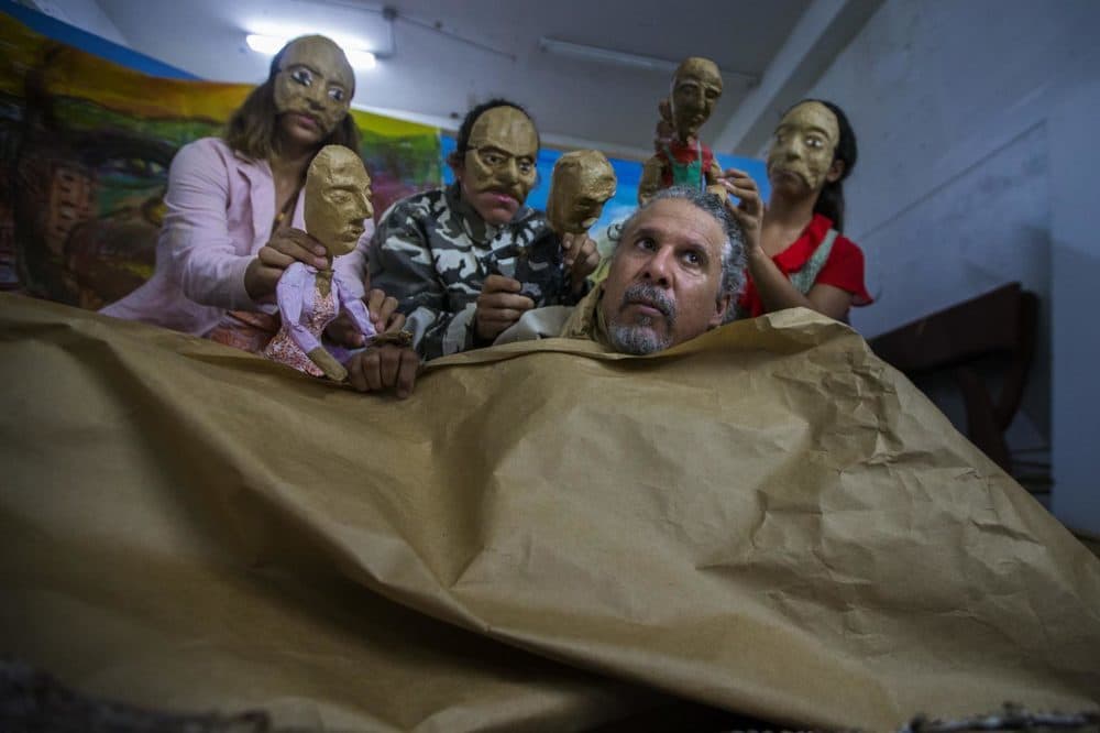 Pedro Adorno, al frente, y parte de su compañía de teatro Agua, Sol, y Sereno, ensayan su espectáculo: "Corazón de Papel: La historia de un huracán", una representación del desastre posterior a María. (Jesse Costa/WBUR)