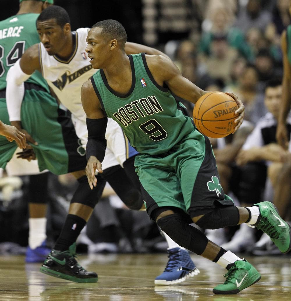 Celtics guard Rajon Rondo drives with ball as he is covered by Washington W...