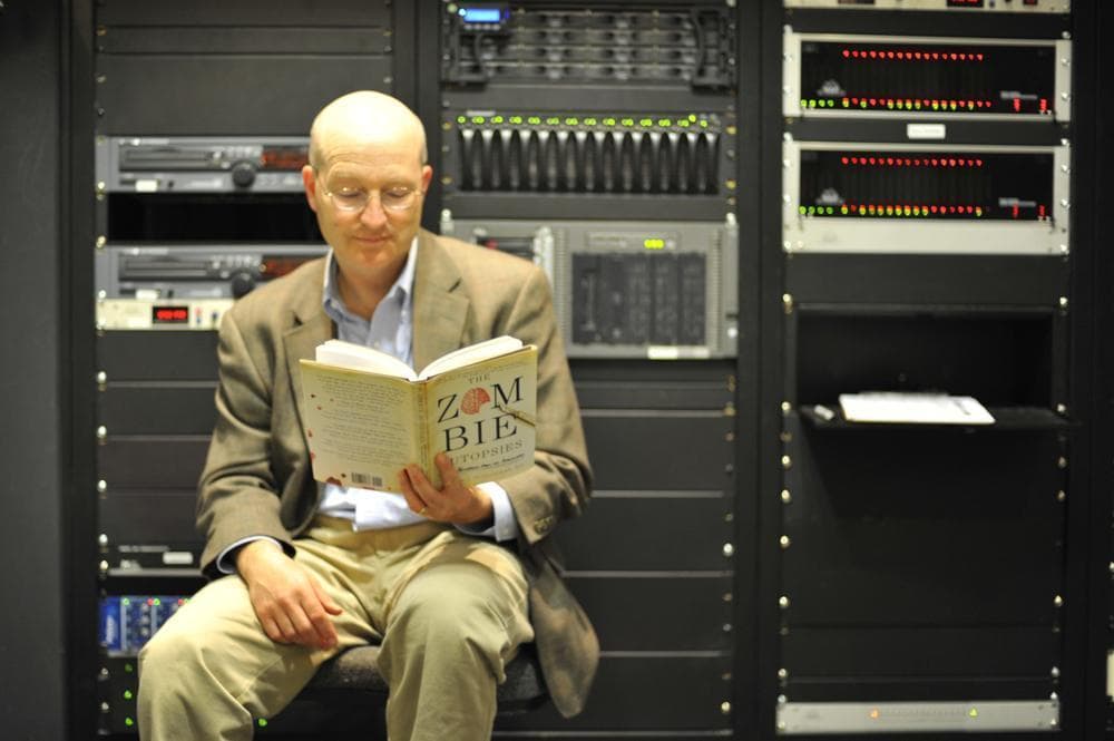Steven Schlozman, author of “The Zombie Autopsies,” reads up on his new book, before heading into the "On Point" studio at WBUR. (Alex Kingsbury/WBUR)