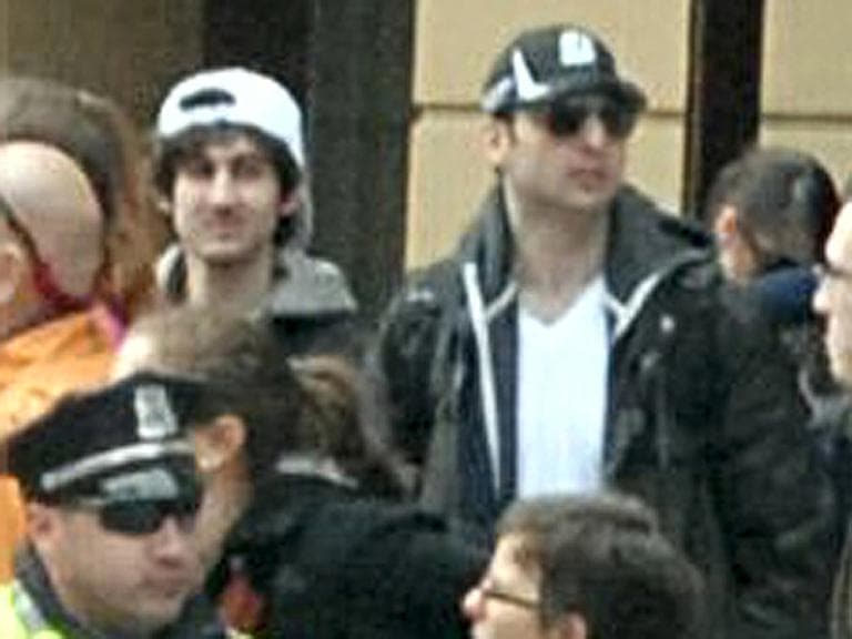 The FBI released this image early Friday, April 19, 2013, showing "Suspect 1" in the white cap and "Suspect 2" in the black cap, walking through the crowd in Boston on Monday, April 15, 2013, before the explosions at the Boston Marathon. (FBI/AP)