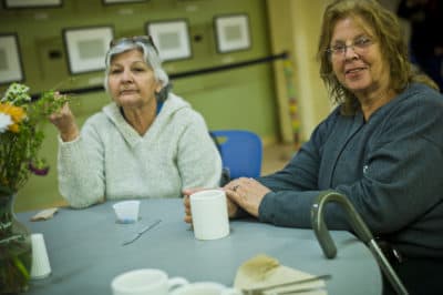 Two women enjoy coffee and some candy following their meal at the Women's Lunch Place on Newbury Street. (Dominick Reuter for WBUR)