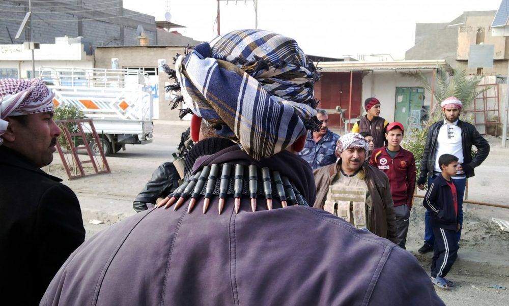 Armed tribesmen and Iraqi police stand guard in a street as clashes rage on in the Iraqi city of Ramadi, west of Baghdad, on January 2, 2014. (Azhar Shallal/AFP/Getty Images)