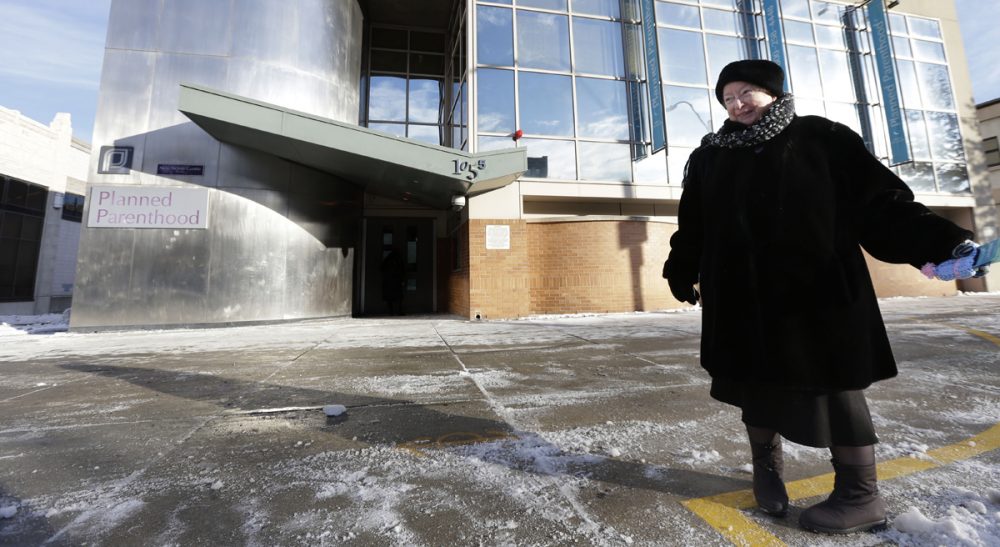 This photo taken Dec. 17, 2013 shows anti-abortion protester Eleanor McCullen, of Boston, standing at the painted edge of a buffer zone outside a Planned Parenthood location in Boston. With her pleasant demeanor and grandmotherly mien, McCullen has become the new face of a decades-old fight between abortion opponents asserting their right to try to change the minds of women seeking abortions and abortion providers claiming that patients should be able to enter their facilities without being impeded or harassed. (Steven Senne/AP))