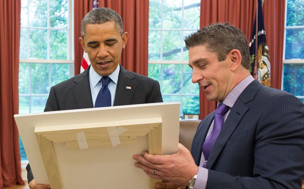 President Barack Obama and Richard Blanco look at a framed copy of "One Today," in the Oval Office, May 20, 2013. (Official White House Photo by Pete Souza)
