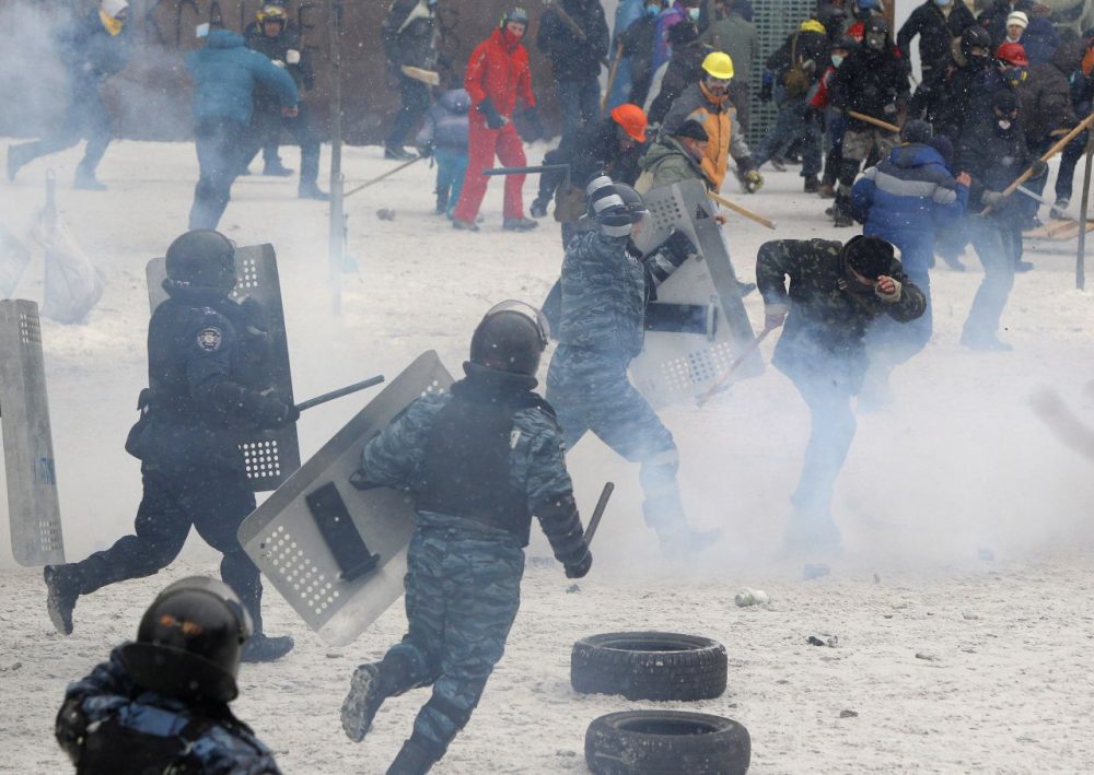 A police officer beats a protester during clashes in central Kiev, Ukraine, Wednesday. (Sergei Grits/AP)