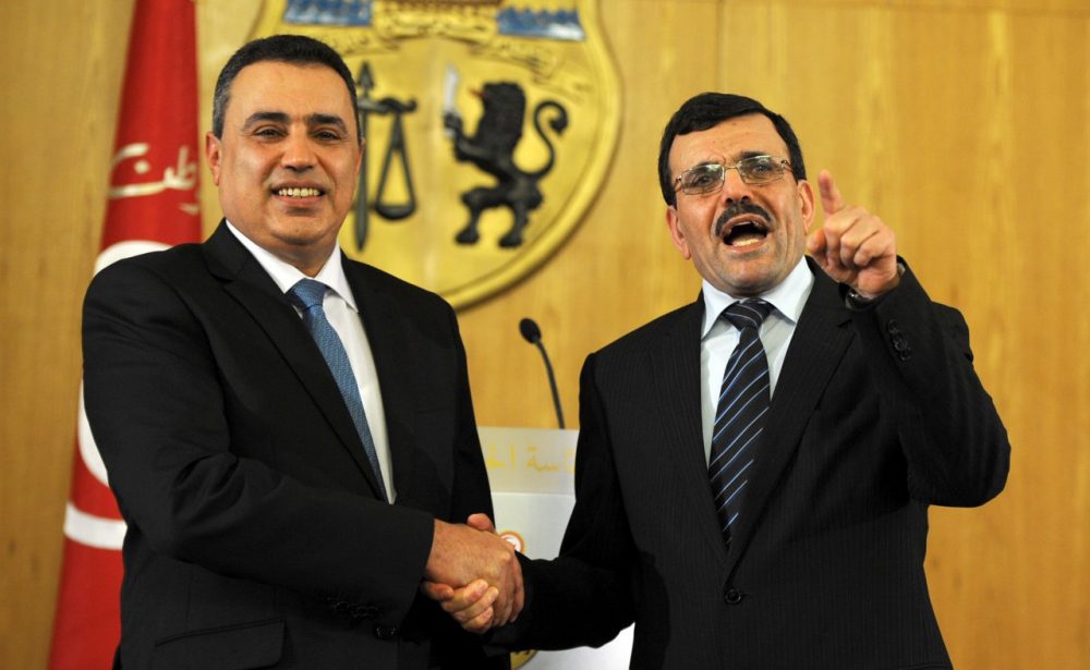 Tunisia's new Prime minister Mehdi Jomaa (left) shakes hands with his predecessor Ali Laarayedh during a handover ceremony in Tunis on January 29, 2014. (Fethi Belaid/AFP/Getty Images)
