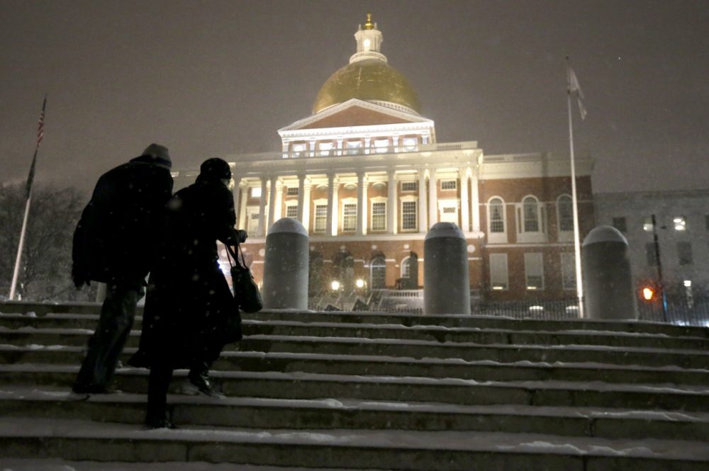 Passers-by ascend snow-covered stairs near the Statehouse, Tuesday, Jan. 21, 2014, in Boston. Heavy snow has been forecast and a blizzard warning was posted for portions of Massachusetts Tuesday, prompting Gov. Deval Patrick to dismiss nonemergency state workers early and postpone his annual State of the State address. (AP)