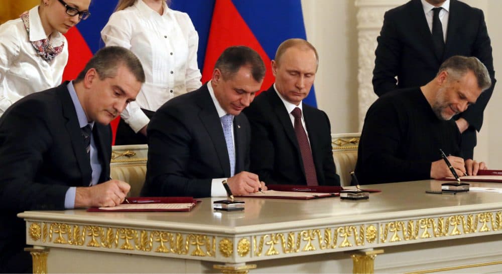 Russian President Vladimir Putin, second right, looks on as Crimean leaders sign a treaty for Crimea to join Russia in the Kremlin in Moscow, Tuesday, March 18, 2014. On the same day, Putin signed a treaty to incorporate Crimea into Russia, describing the move as the restoration of historic injustice and a necessary response to what he called the Western encroachment on Russia’s vital interests. (Sergei Ilnitsky/AP)