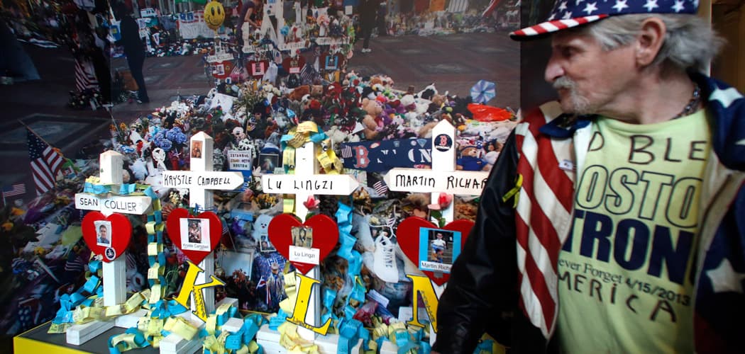 Kevin Brown pauses to look at an exhibit entitled "Dear Boston: Messages from the Marathon Memorial" at the Boston Public Library on Monday. Brown, a carpenter, constructed the cross that is displayed for fallen MIT Officer Sean Collier. (Elise Amendola/AP)