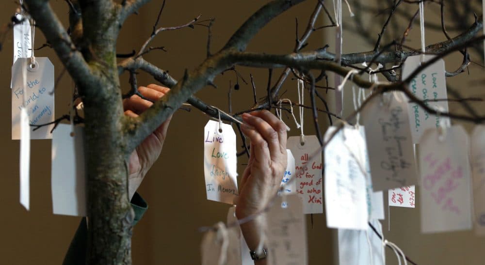 The anniversary of the Marathon may make people feel as if it's time for closure, but the truth is each person recovers from loss at a different pace. In this photo, a woman hangs a tag on a message tree at an exhibit entitled "Dear Boston: Messages from the Marathon Memorial" at the Boston Public Library in Boston, Monday, April 7, 2014. (Elise Amendola/AP)