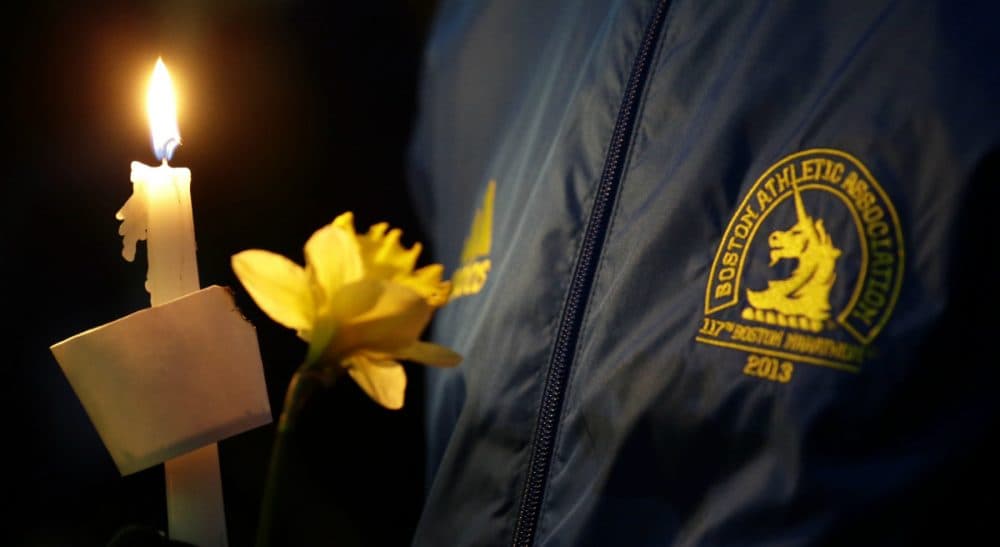 The first anniversary of the marathon attack has Anita Diamant thinking about the families of those who lost their lives. This photo was taken at a vigil for the victims of the Boston Marathon explosions, Tuesday April 16, 2013. (Julio Cortez/AP)