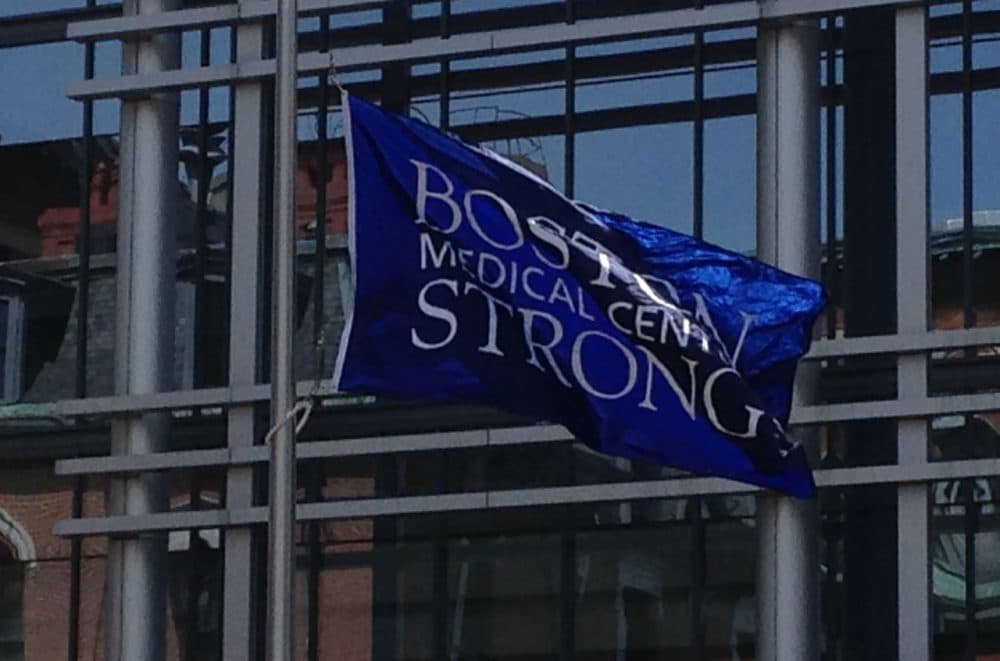 A flag that says "Boston Medical Center Strong" waves outside of Boston Medical Center, a year after the Boston Marathon bombing. (Ron Medzon)