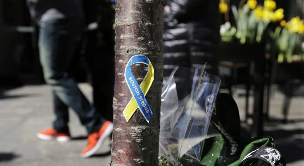 Social critic Wendy Kaminer says, for better or worse, the Boston Marathon is no longer an athletic event -- it's an icon. In this photo, a patron enters the Forum restaurant, site of one of two bomb blasts during the 2013 Marathon, while passing a "Boston Strong" sticker adhered to a tree trunk at a makeshift memorial on Boylston Street. Wednesday, April 16, 2014 in Boston. (Charles Krupa/AP)