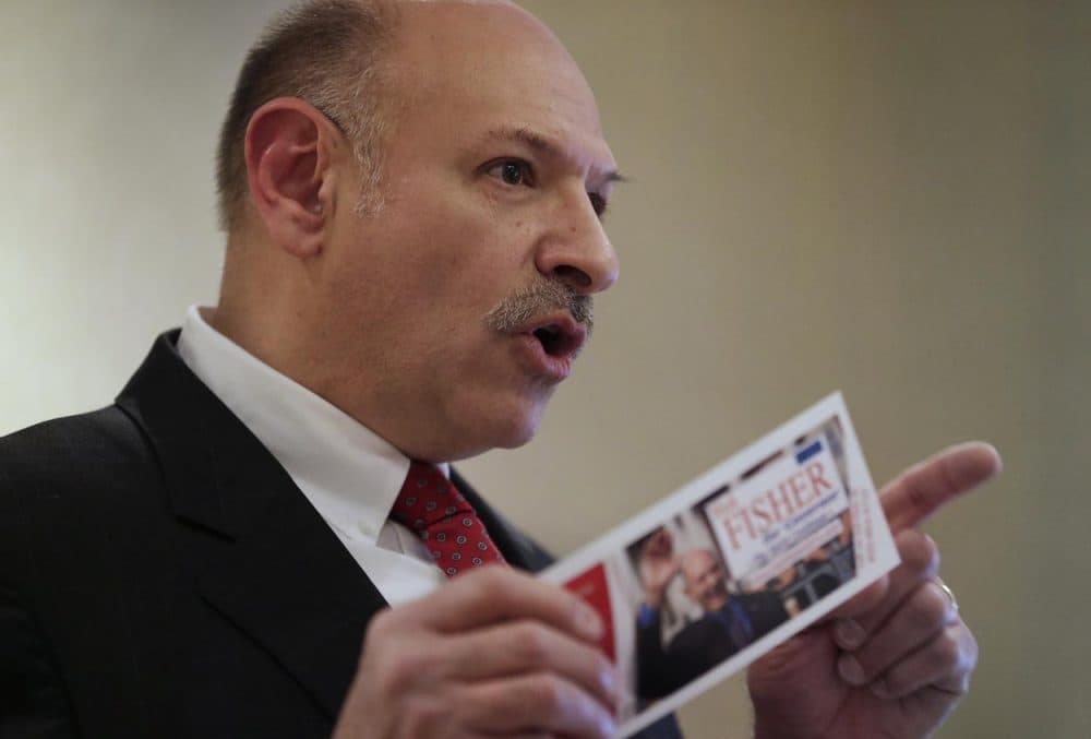 Republican candidate for governor of Massachusetts Mark Fisher displays a campaign brochure while facing reporters during a news conference Thursday. (Steven Senne/AP)