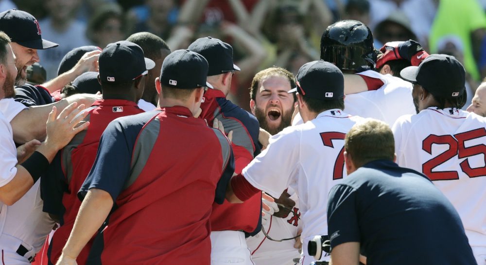 Boston Red Sox's Mike Napoli, center, smiles as he is congratulated by teammates after hitting the game-winning, walk-off home run against the Minnesota Twins in the 10th inning of a baseball game at Fenway Park in Boston, Wednesday, June 18, 2014. The Red Sox won 2-1 in 10 innings. (Charles Krupa/AP)